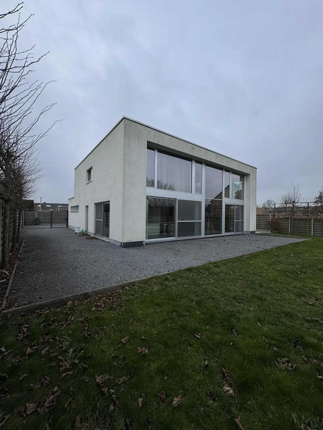 Vervuilde crepi gevel met groene aanslag voor reiniging in Waregem